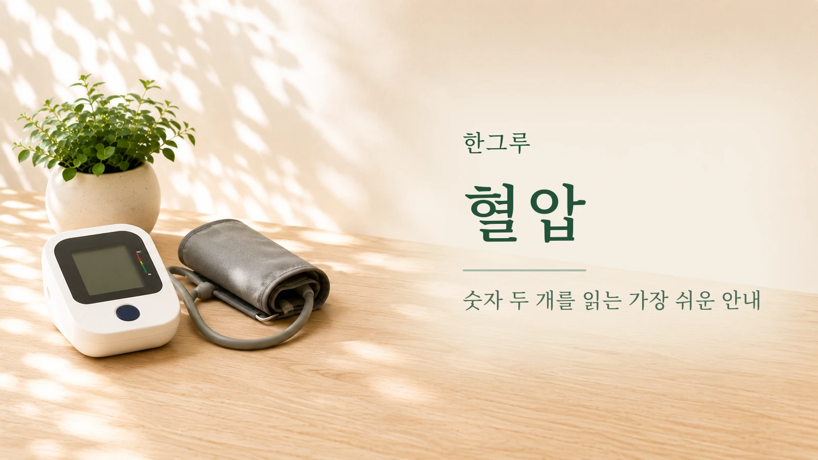 나무 탁자 위 가정용 전자혈압계와 커프, 초록 화분