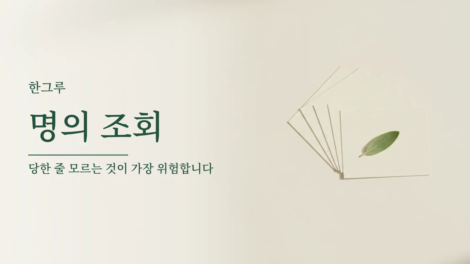 흰 탁자 위에 놓인 빈 이름표 카드 여러 장과 초록 잎