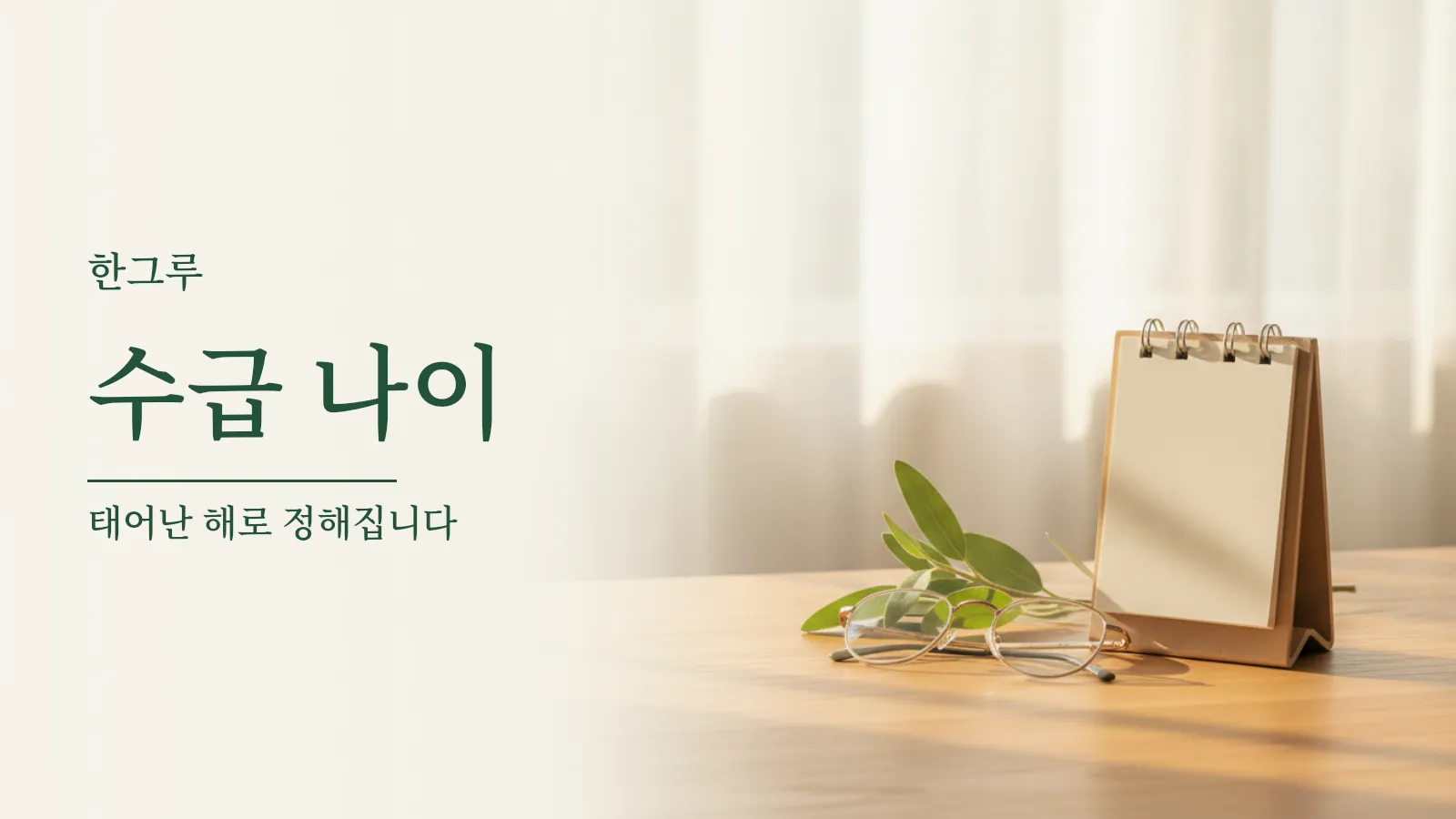 나무 책상 위에 놓인 탁상 달력과 돋보기, 초록 잎