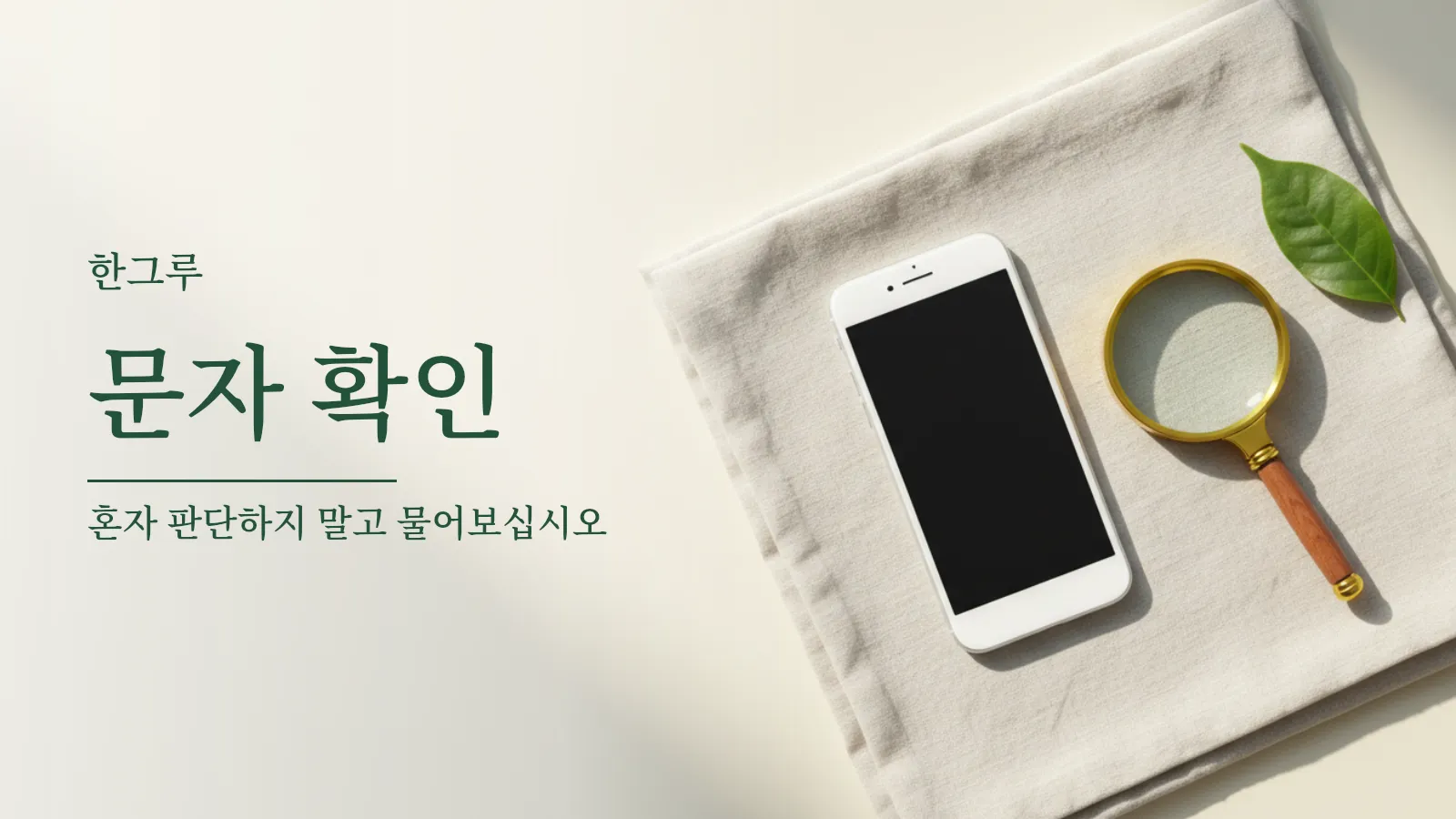 탁자 위에 놓인 스마트폰과 돋보기, 초록 잎 한 장