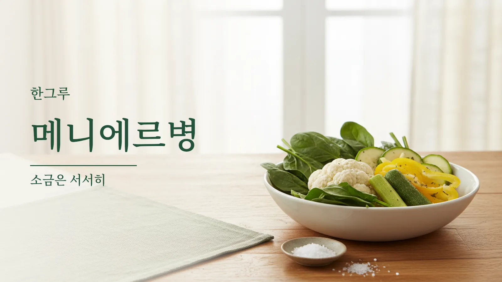 나무 식탁에 놓인 채소 한 그릇과 작은 소금 접시